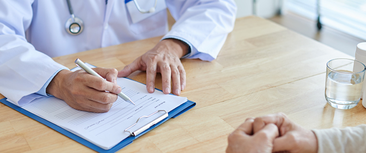 Manos de médico escribiendo
