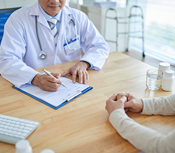 Manos de médico escribiendo