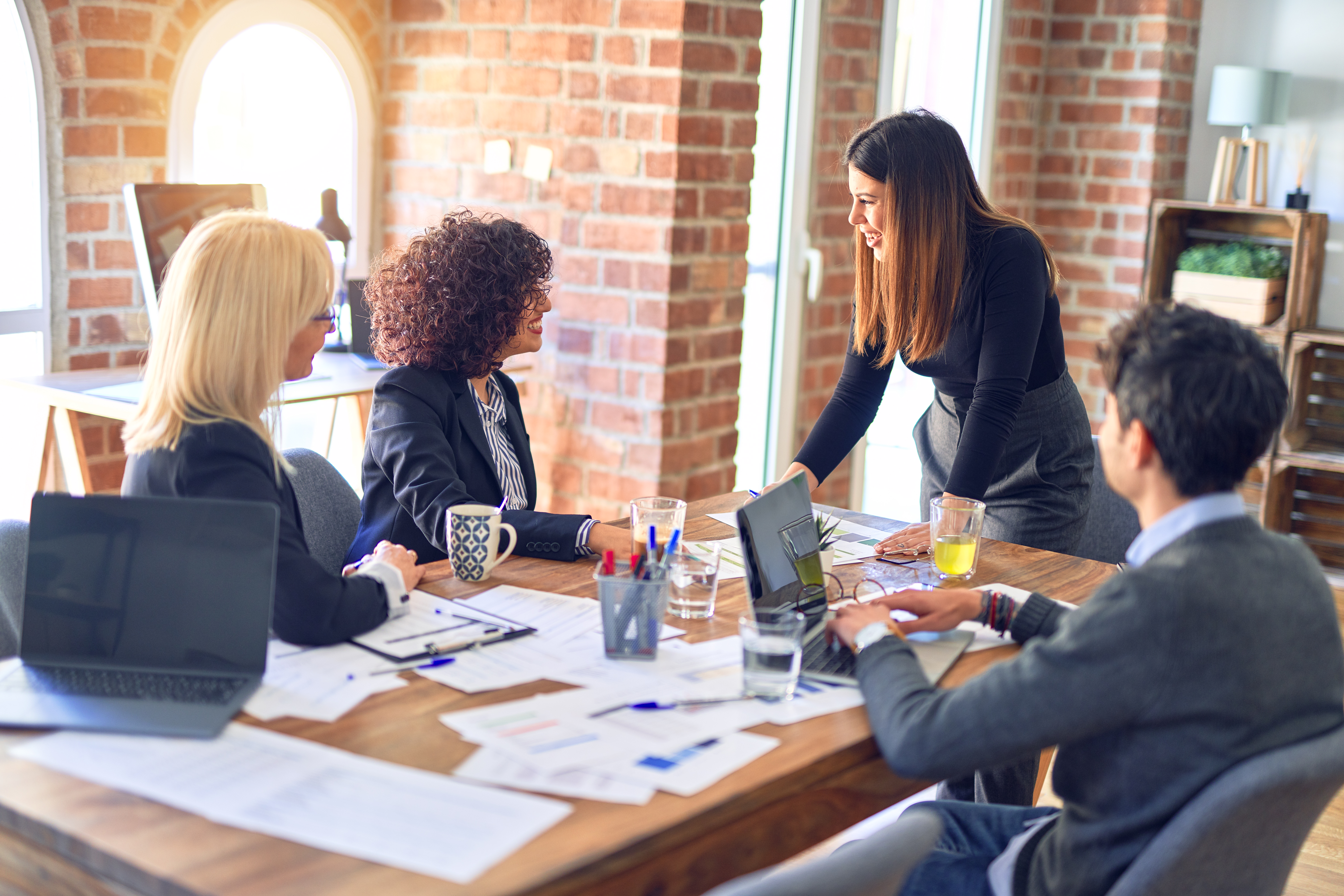 group-business-workers-smiling-happy-confident-working-together-with-smile-face-young-beautiful-woman-standing-explaining-documents-office